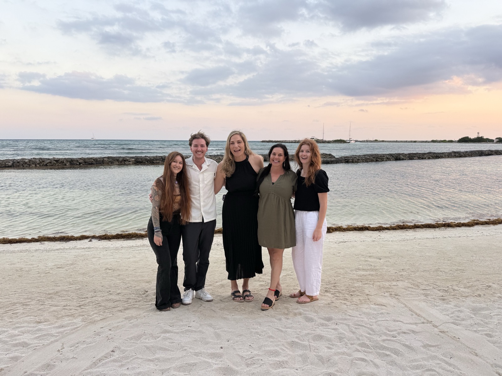 Qualia team members on the beach at sunset
