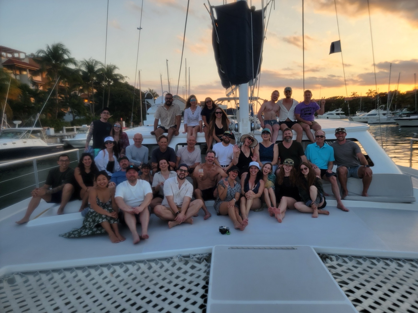 Qualia team on a catamaran at sunset during a company retreat