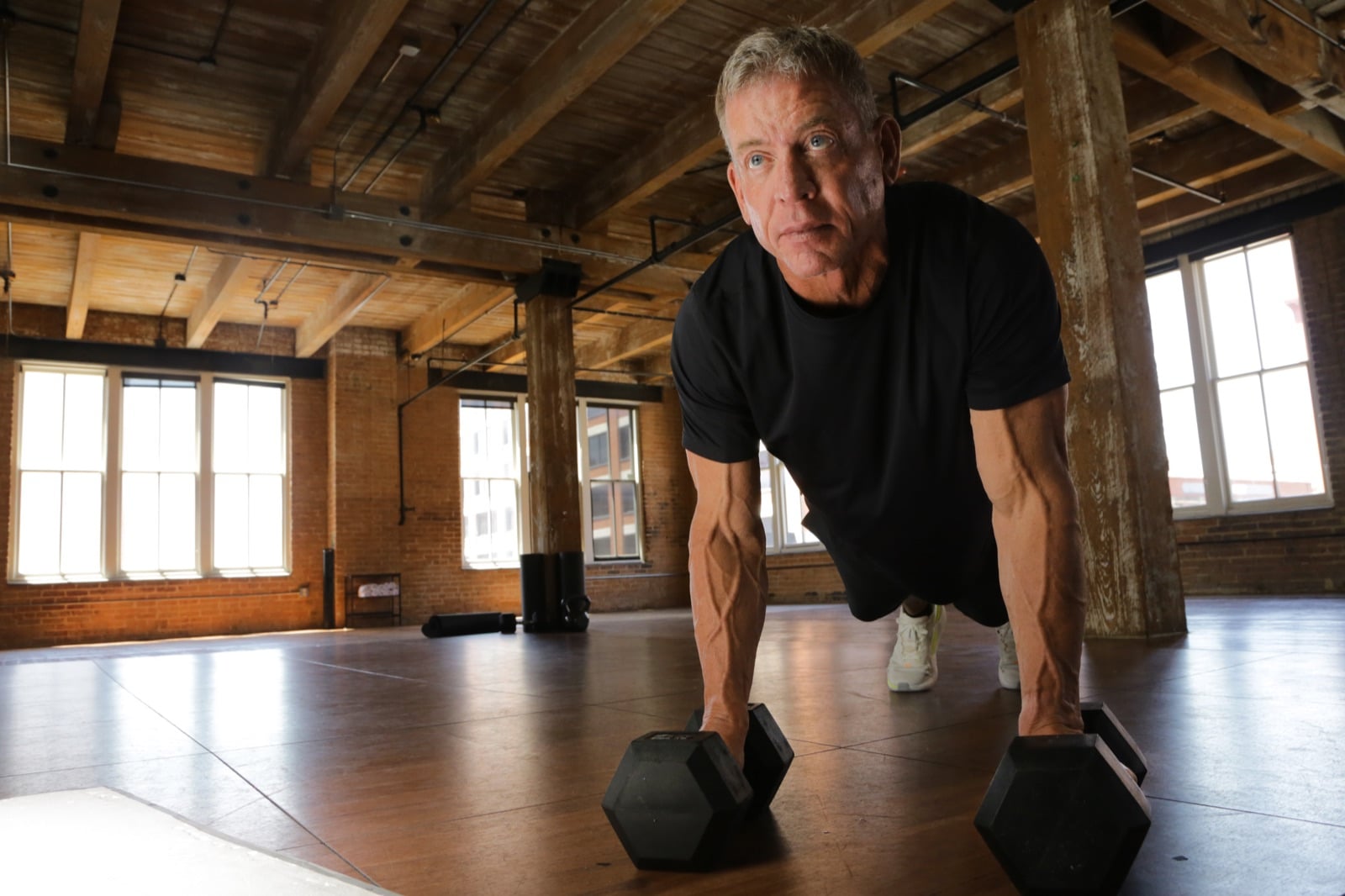 Troy Aikman doing a push-up on dumbbells